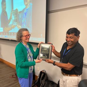 Shivaji receiving plaque from Suzanne Lenhart